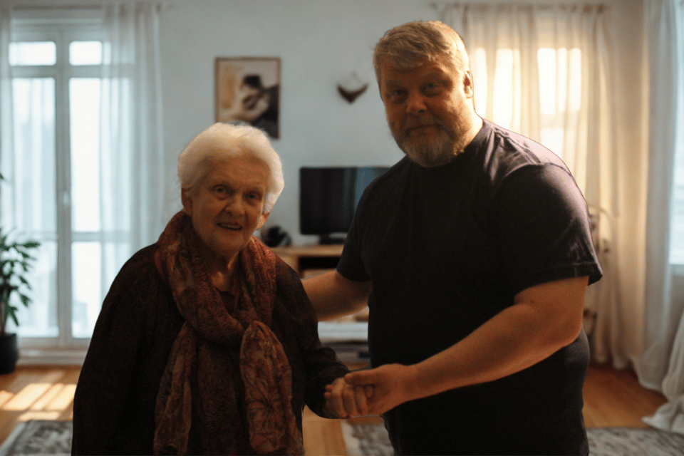 Hoitaja auttaa ikäihmistä kotona